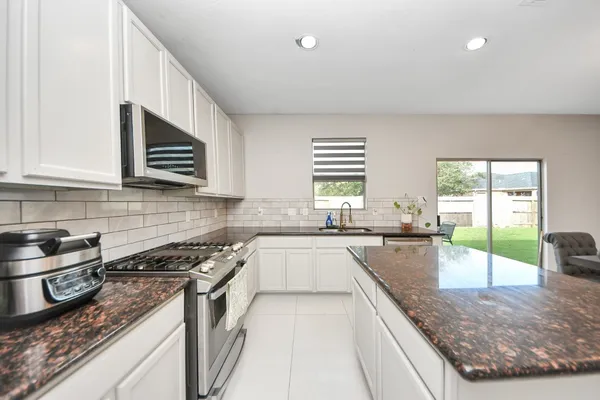 a kitchen with sink stove and cabinets