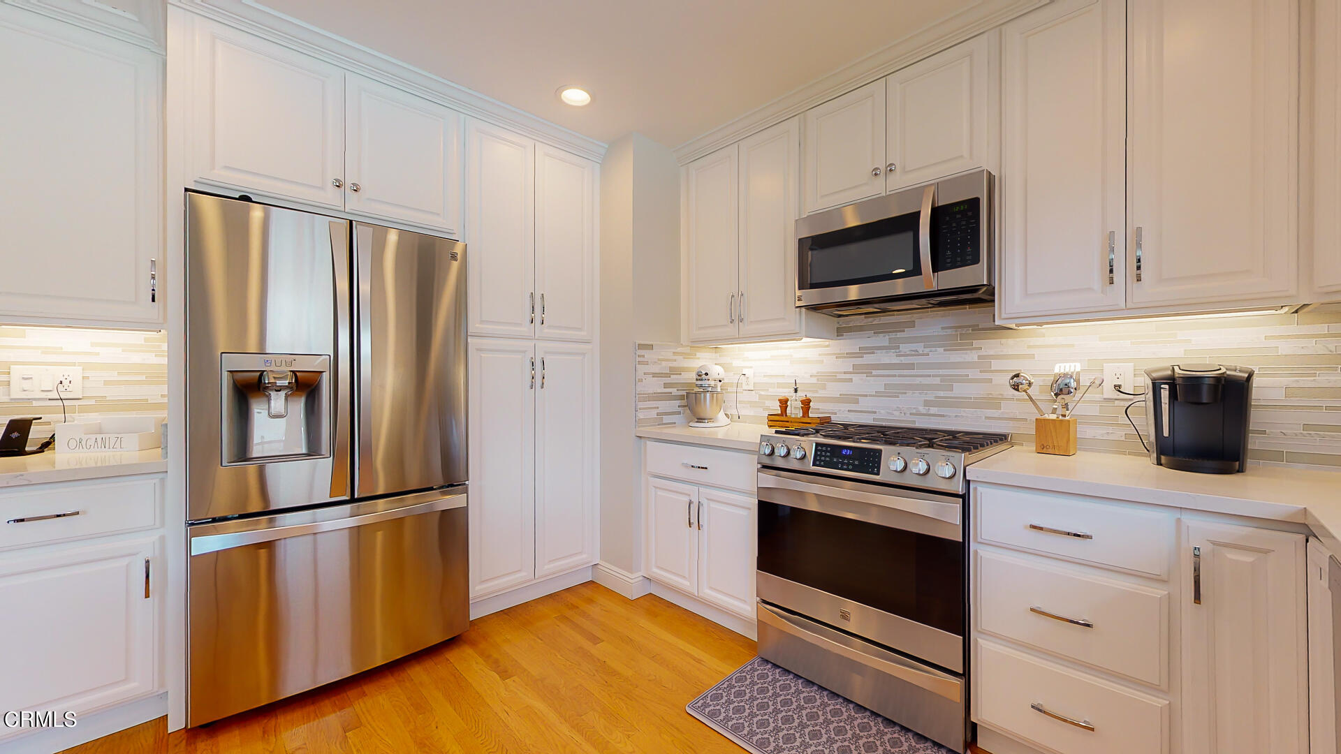 11052 Corley Drive Whittier, CA 90604 - Photo 12 of 39 a kitchen with stainless steel appliances white cabinets white stove a microwave and a refrigerator