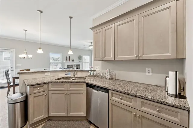 a kitchen with a sink dishwasher and white cabinets with wooden floor