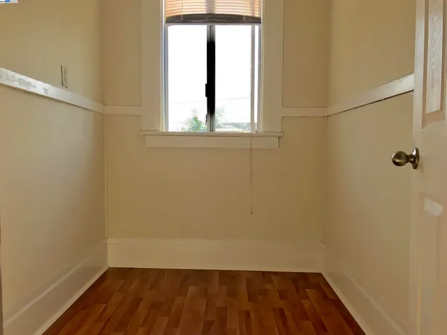 a view of a small space with wooden floor and a window