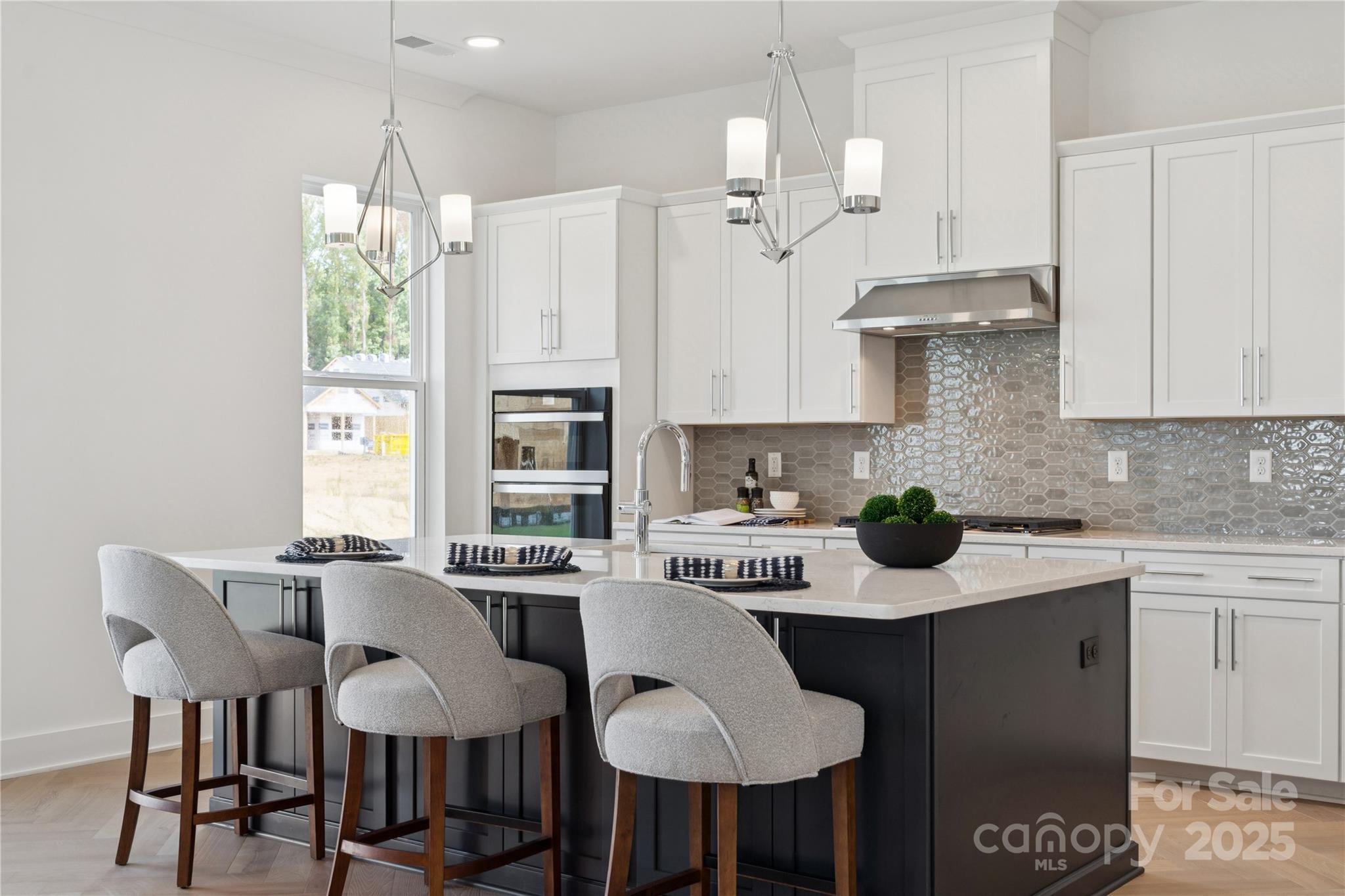 5305 Vernon Rdg Road, Unit 117 Huntersville, NC 28078 - Photo 6 of 11 a kitchen with stainless steel appliances a table chairs refrigerator and cabinets