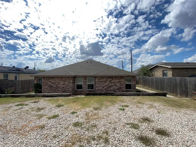a view of a house with a yard and large tree