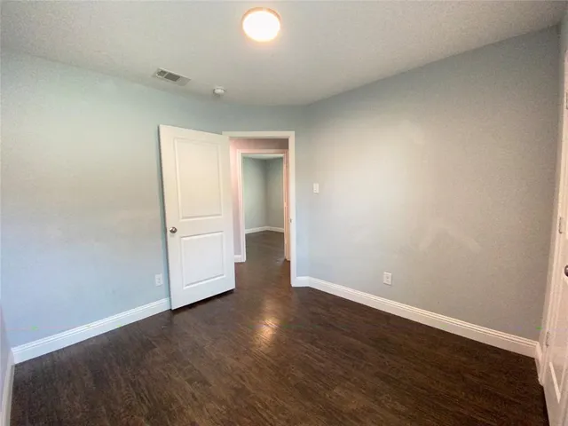 an empty room with wooden floor and white walls