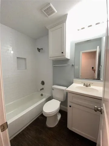a bathroom with a granite countertop toilet a sink and bathtub