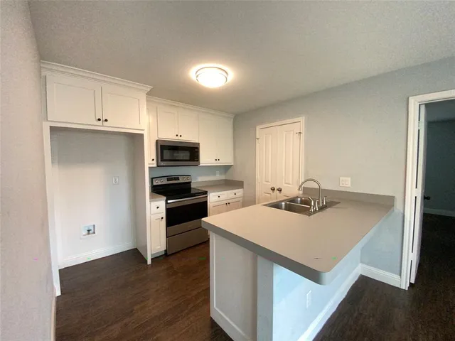 a kitchen with a sink a stove a refrigerator and a microwave