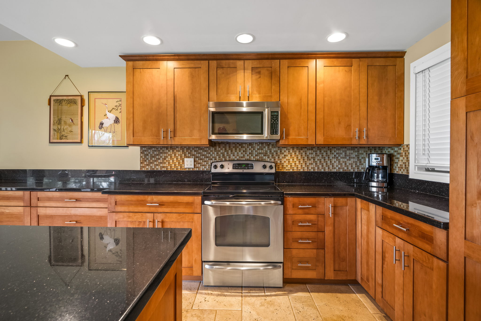 2370 Ho'ohu Road, Unit 712 Koloa, HI 96756 - Photo 12 of 28 a kitchen with stainless steel appliances granite countertop a stove a sink and a microwave