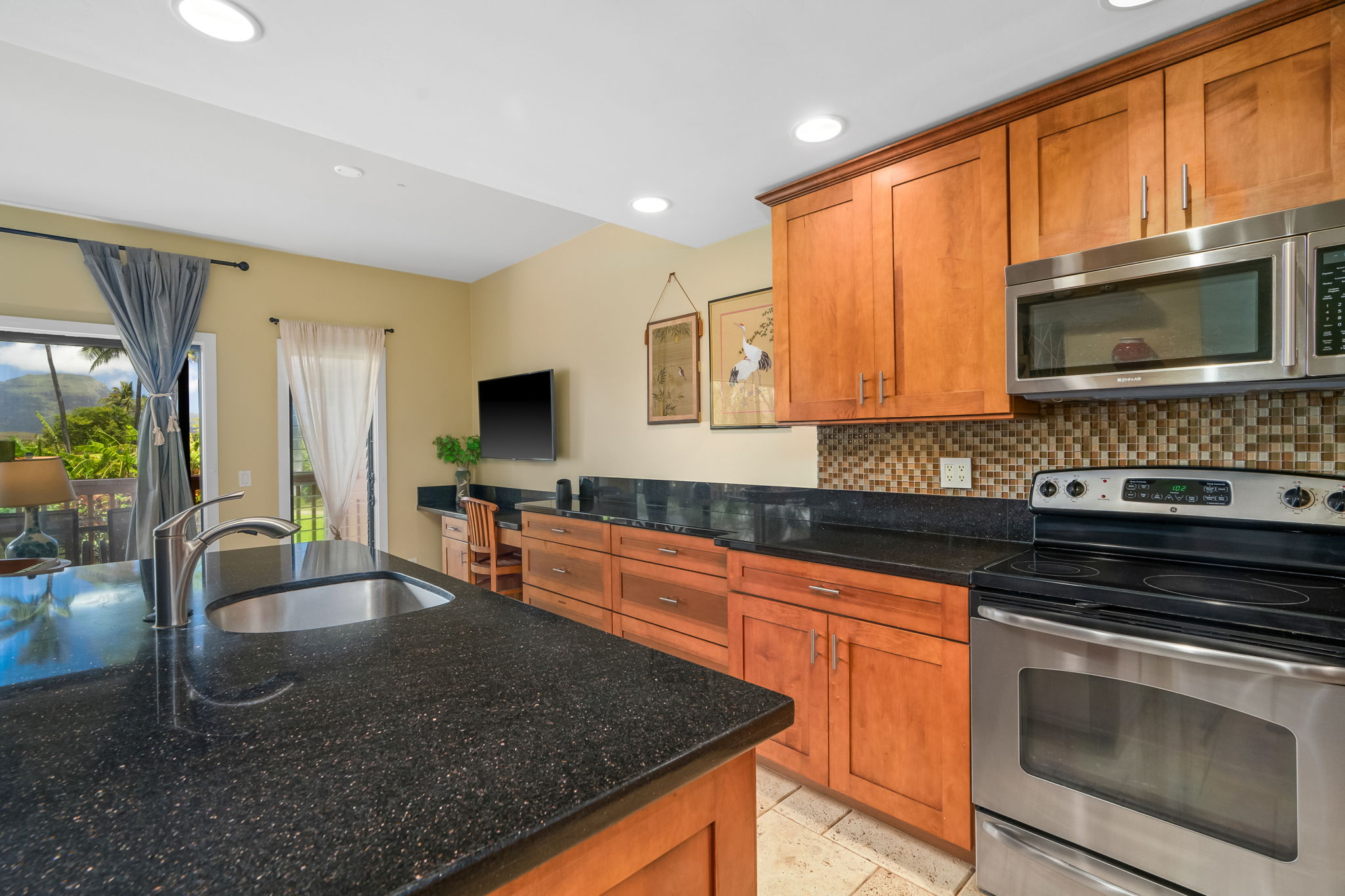 2370 Ho'ohu Road, Unit 712 Koloa, HI 96756 - Photo 13 of 28 a kitchen with stainless steel appliances granite countertop a stove a sink and a microwave