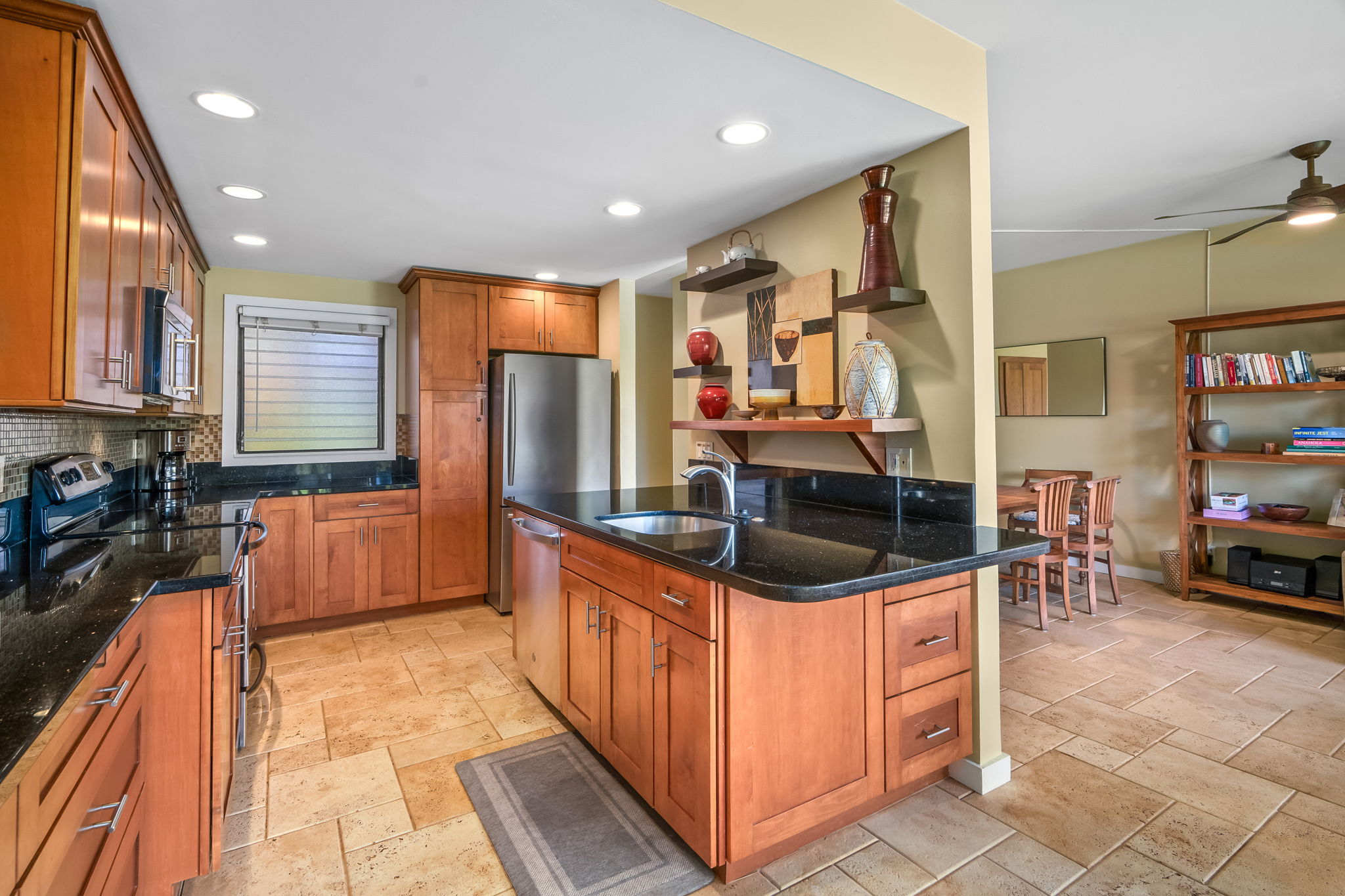 2370 Ho'ohu Road, Unit 712 Koloa, HI 96756 - Photo 14 of 28 a kitchen with stainless steel appliances a stove top oven a sink a dining table and chairs