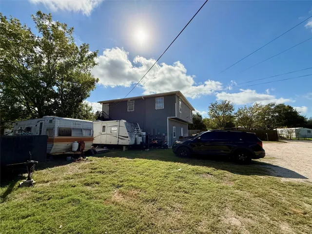 a front view of a house with a yard and a large tree