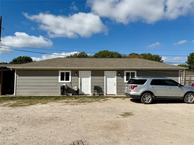 a view of backyard with a table and chairs and wooden fence