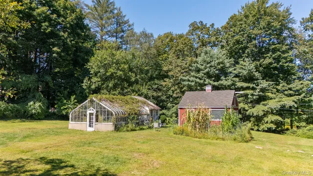 a view of a big house with a yard and large trees