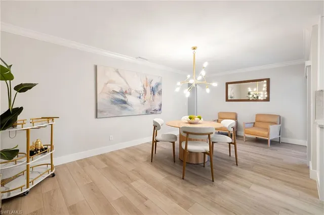a dining room with wooden floor a chandelier a wooden table and chairs