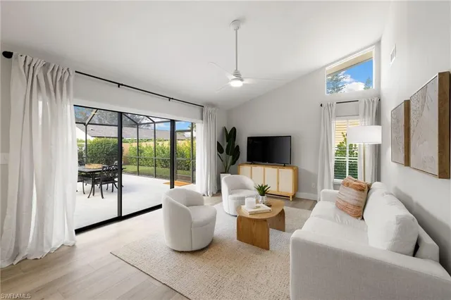 a living room with patio furniture and a flat screen tv