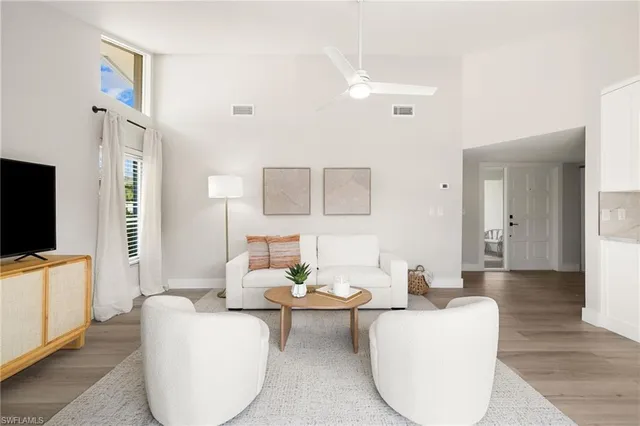 a living room with furniture a flat screen tv and a window