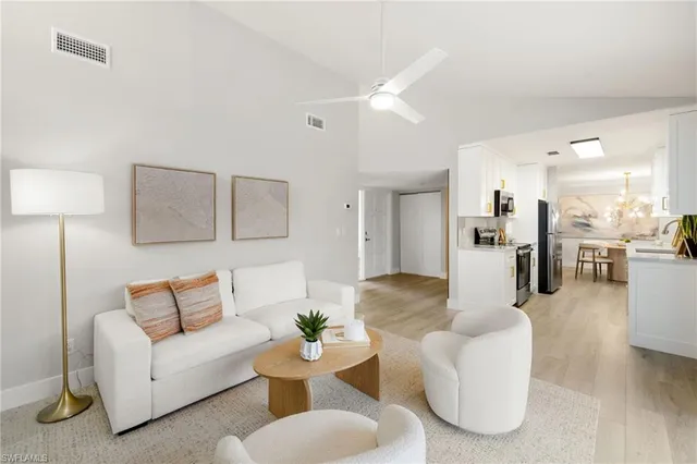 a living room with furniture and kitchen view