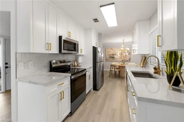 a kitchen with granite countertop a stove top oven a sink a counter space and cabinets