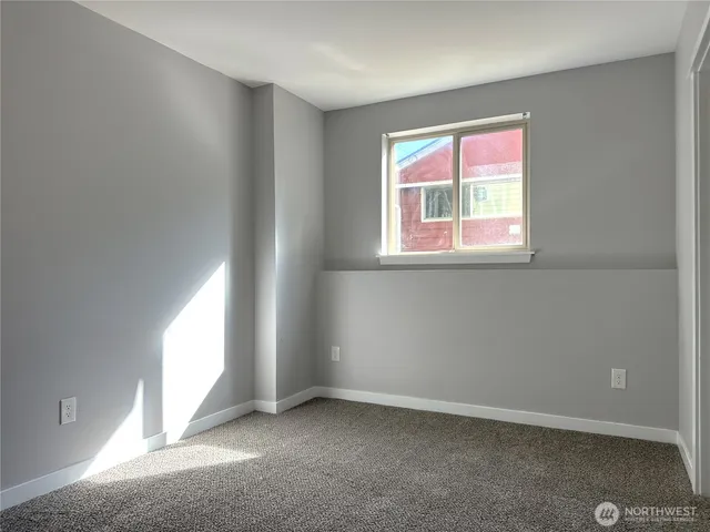 an empty room with windows and closet