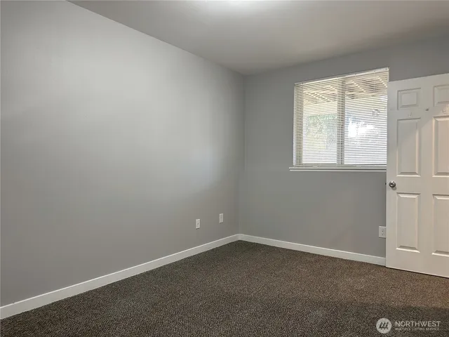 an empty room with closet and a bathroom