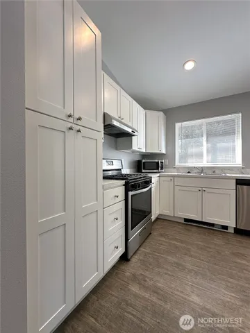 a kitchen with white cabinets and white appliances
