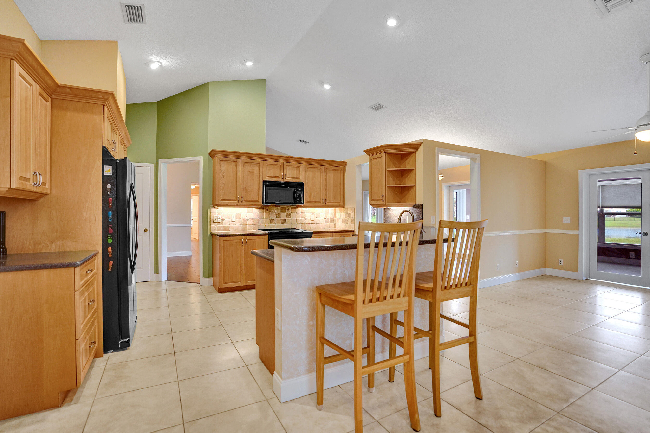 3825 Sabal Lakes Road Delray Beach, FL 33445 - Photo 11 of 33 a kitchen with stainless steel appliances a refrigerator and a stove top oven