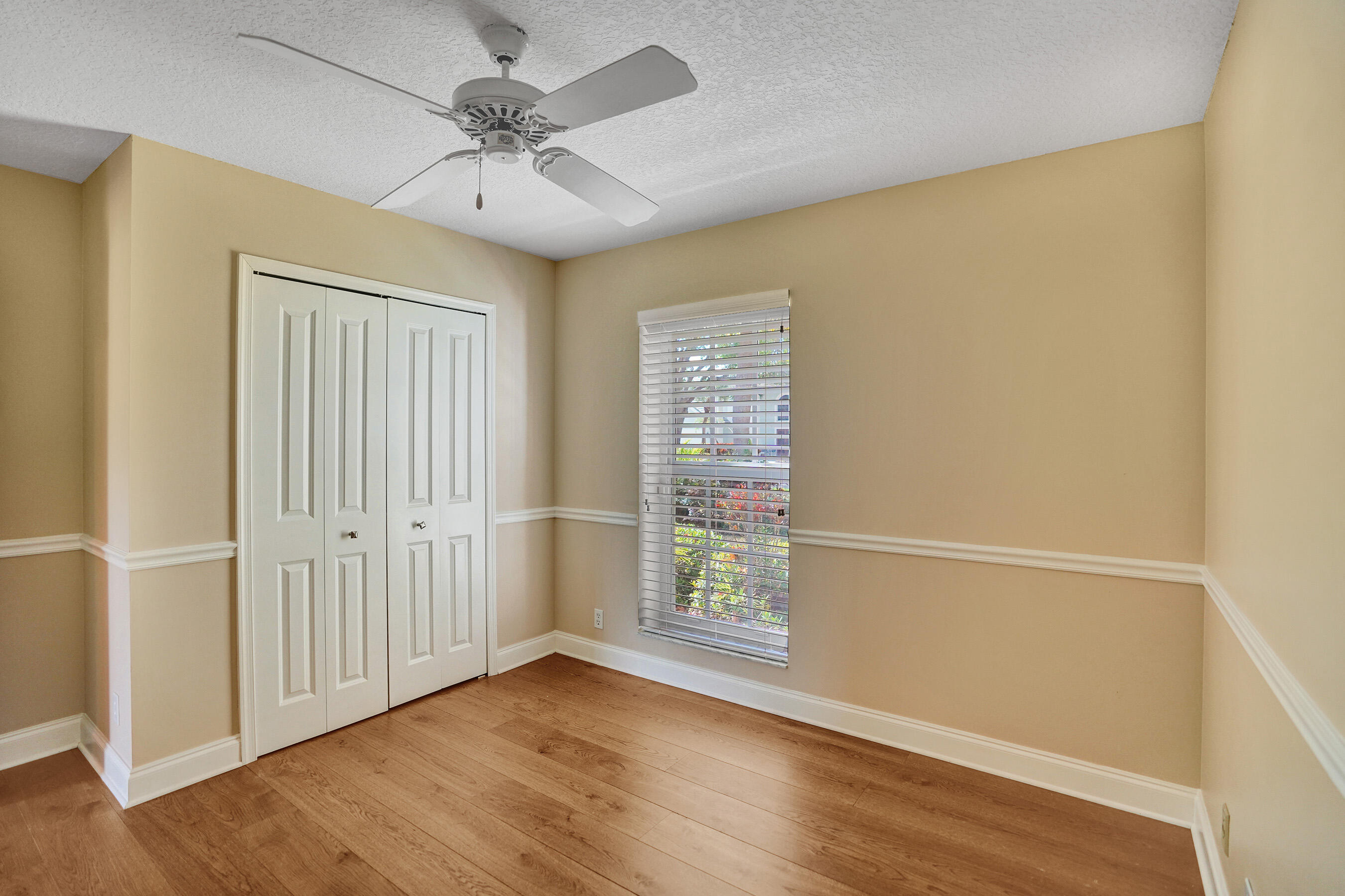 3825 Sabal Lakes Road Delray Beach, FL 33445 - Photo 21 of 33 an empty room with wooden floor fan and windows