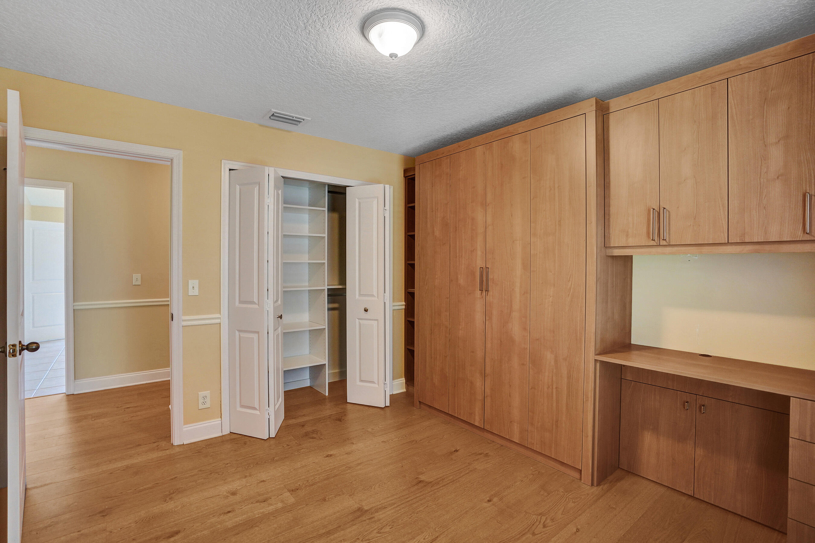 3825 Sabal Lakes Road Delray Beach, FL 33445 - Photo 25 of 33 an empty room with wooden floor and cabinet