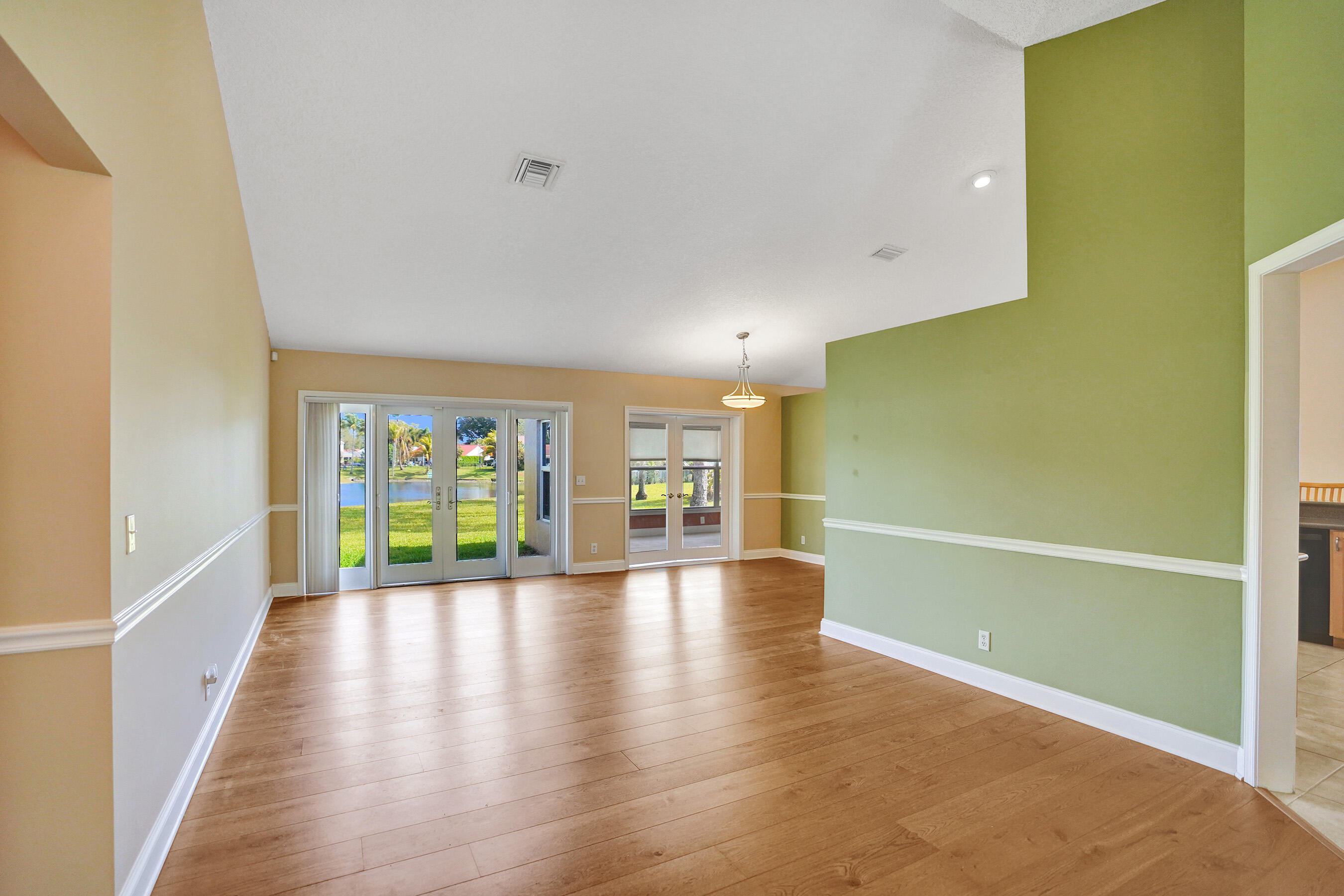 3825 Sabal Lakes Road Delray Beach, FL 33445 - Photo 4 of 33 a view of an empty room with a window and wooden floor