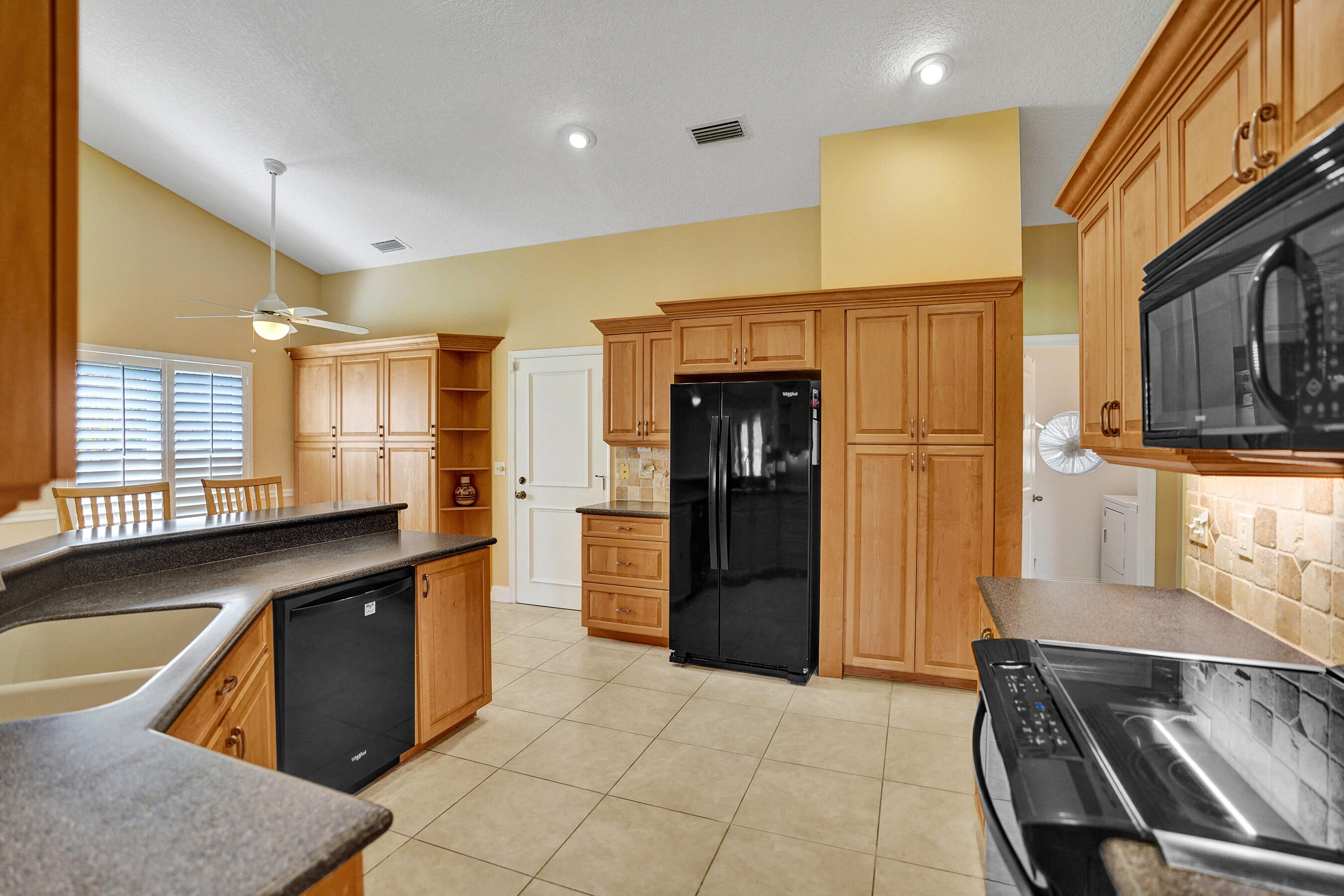 3825 Sabal Lakes Road Delray Beach, FL 33445 - Photo 7 of 33 a kitchen with stainless steel appliances granite countertop a refrigerator and a sink