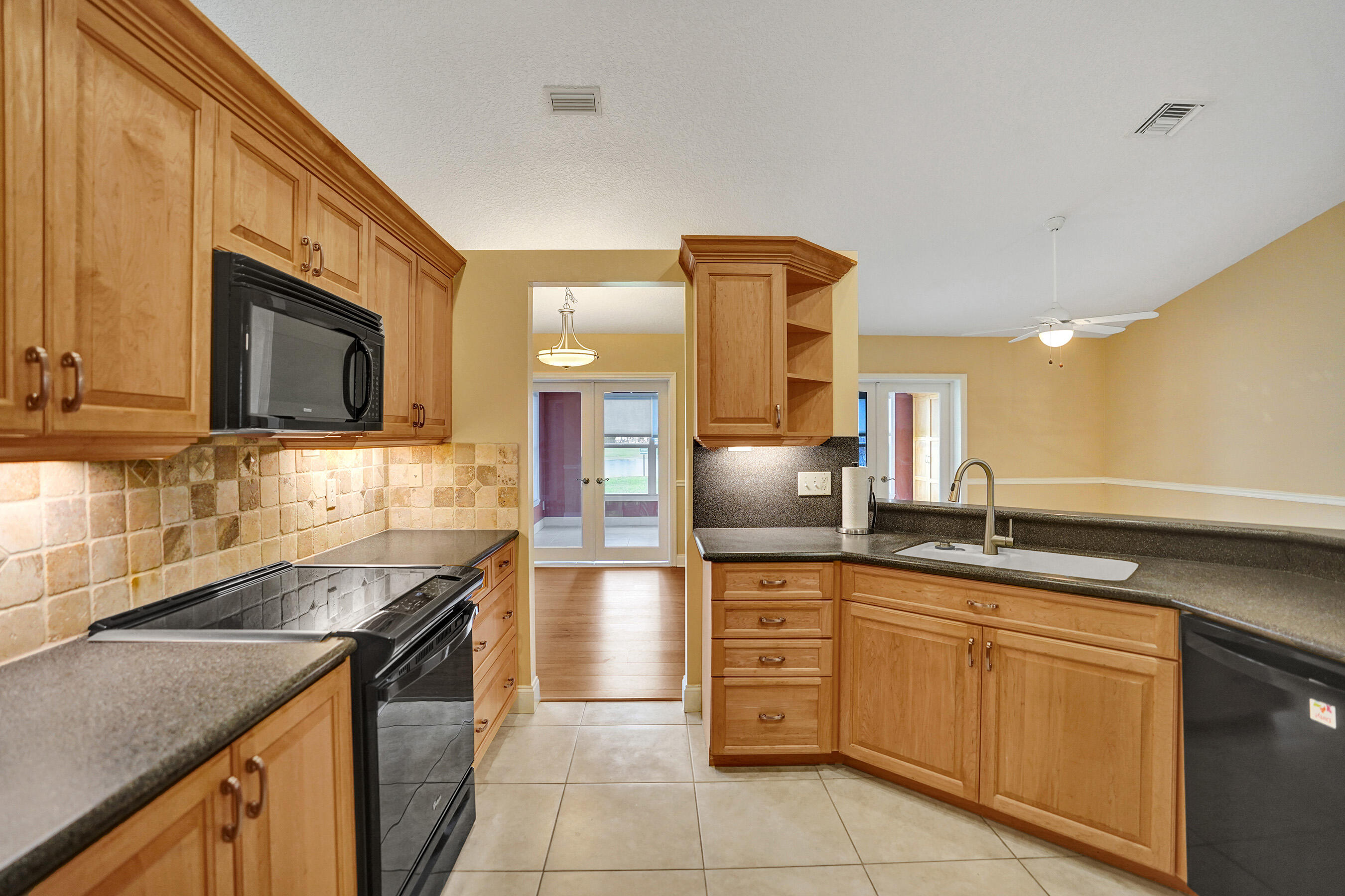3825 Sabal Lakes Road Delray Beach, FL 33445 - Photo 8 of 33 a kitchen with granite countertop a sink and stainless steel appliances