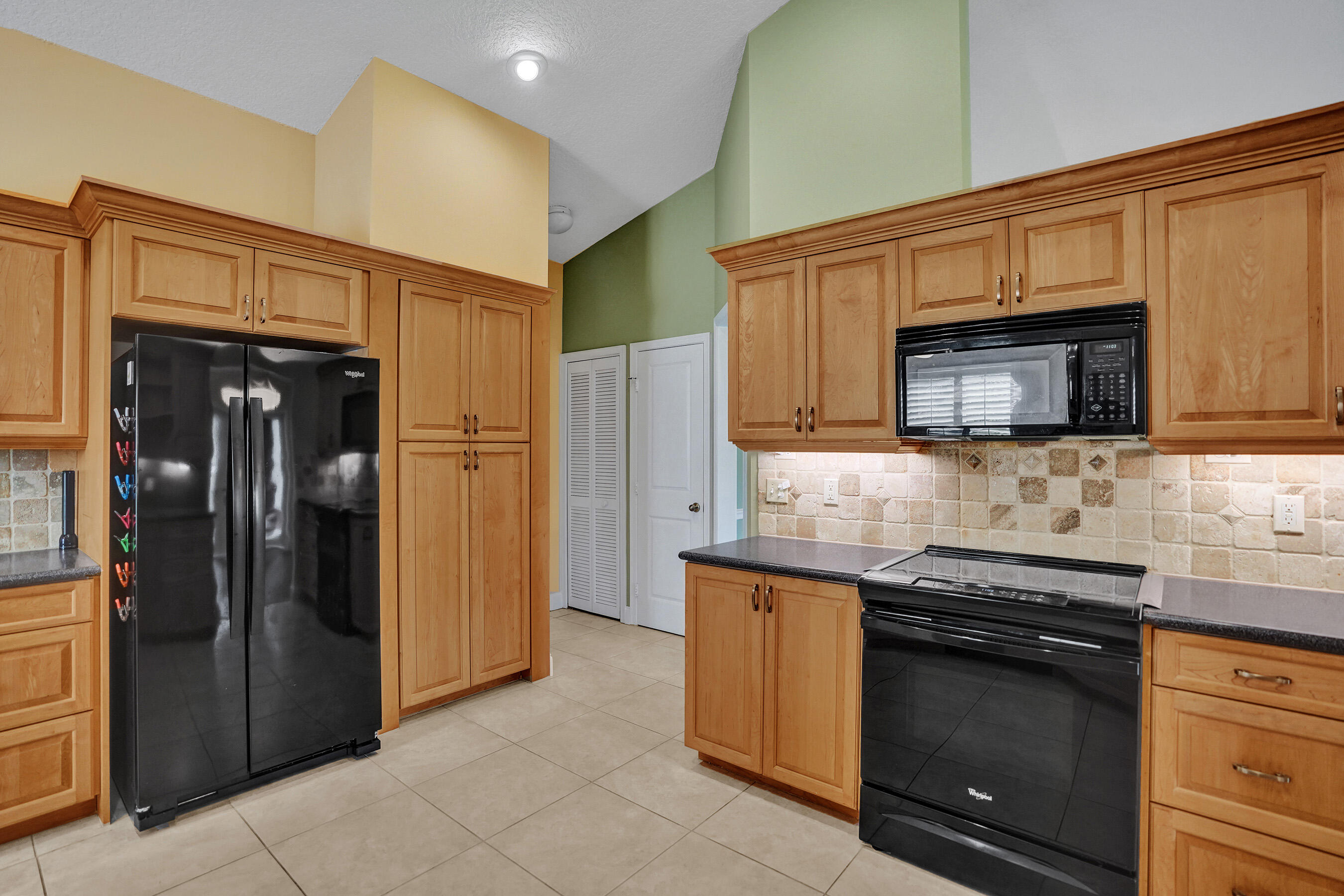 3825 Sabal Lakes Road Delray Beach, FL 33445 - Photo 9 of 33 a kitchen with stainless steel appliances granite countertop a refrigerator and a stove top oven