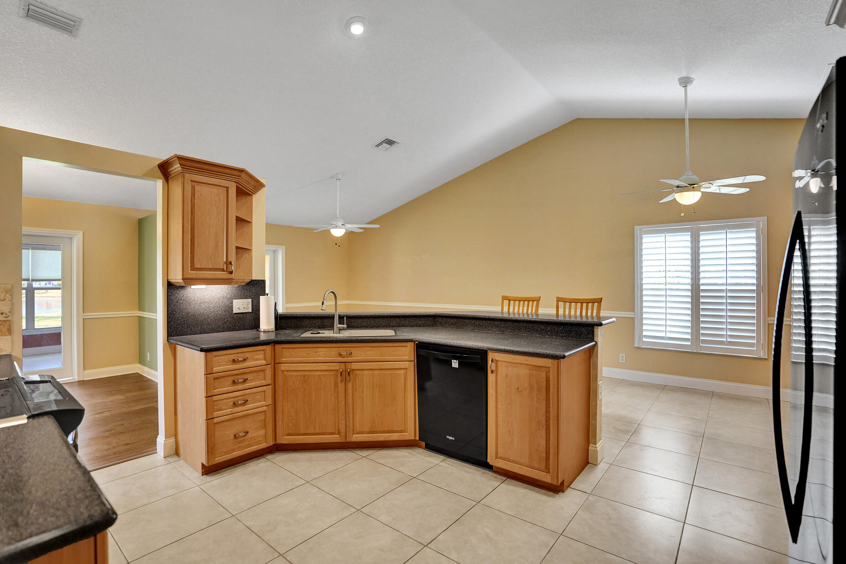 3825 Sabal Lakes Road Delray Beach, FL 33445 - Photo 10 of 33 a kitchen with stainless steel appliances granite countertop a sink and a refrigerator