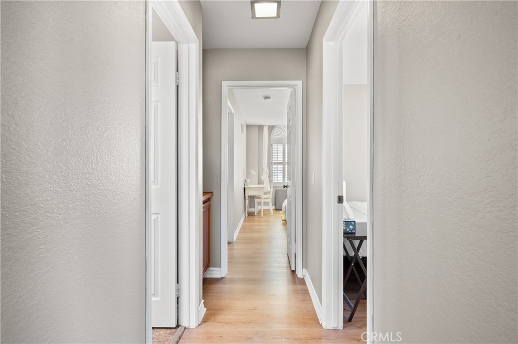 6933 Stanislaus Place Rancho Cucamonga, CA 91701 - Photo 30 of 54 a view of a hallway with wooden floor and a livingroom with a bathroom