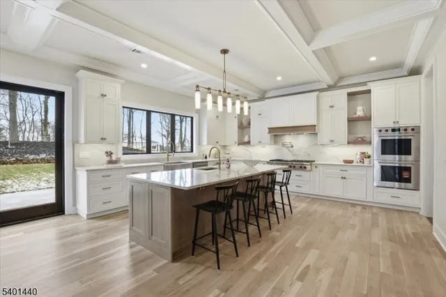 a large kitchen with kitchen island granite countertop a large center island a stove a table and chairs in it