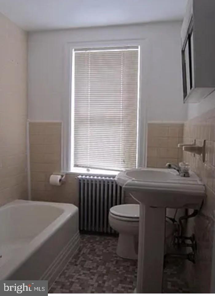 192 Conarroe Street Philadelphia, PA 19127 - Photo 3 of 7 a bathroom with a sink a bathtub and next to a window