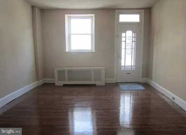 a view of a livingroom with wooden floor and window