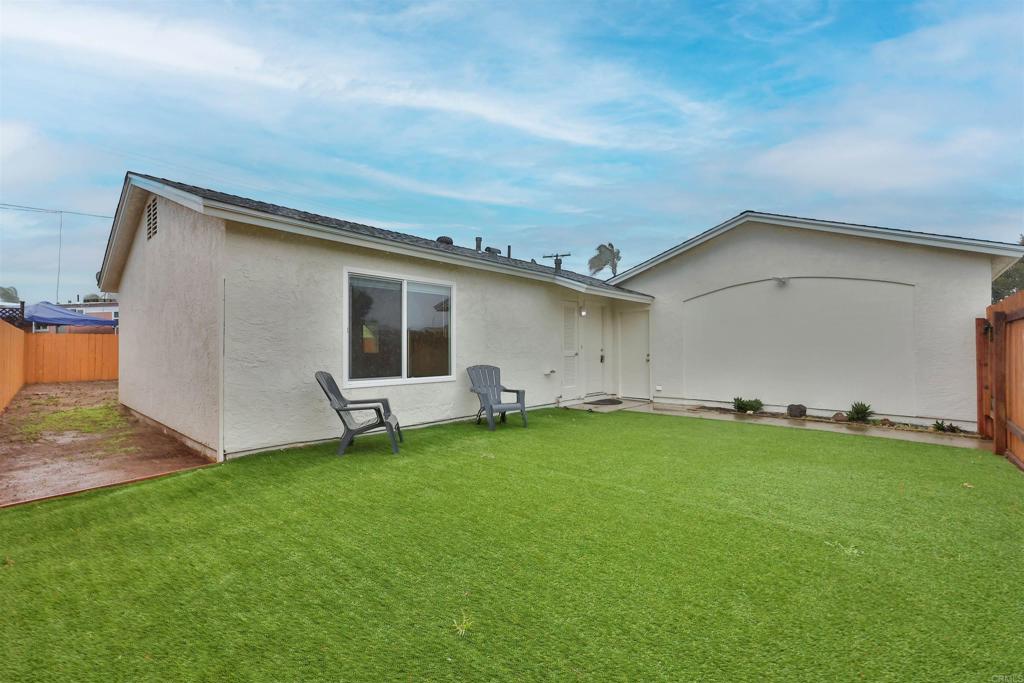 a backyard of a house with table and chairs