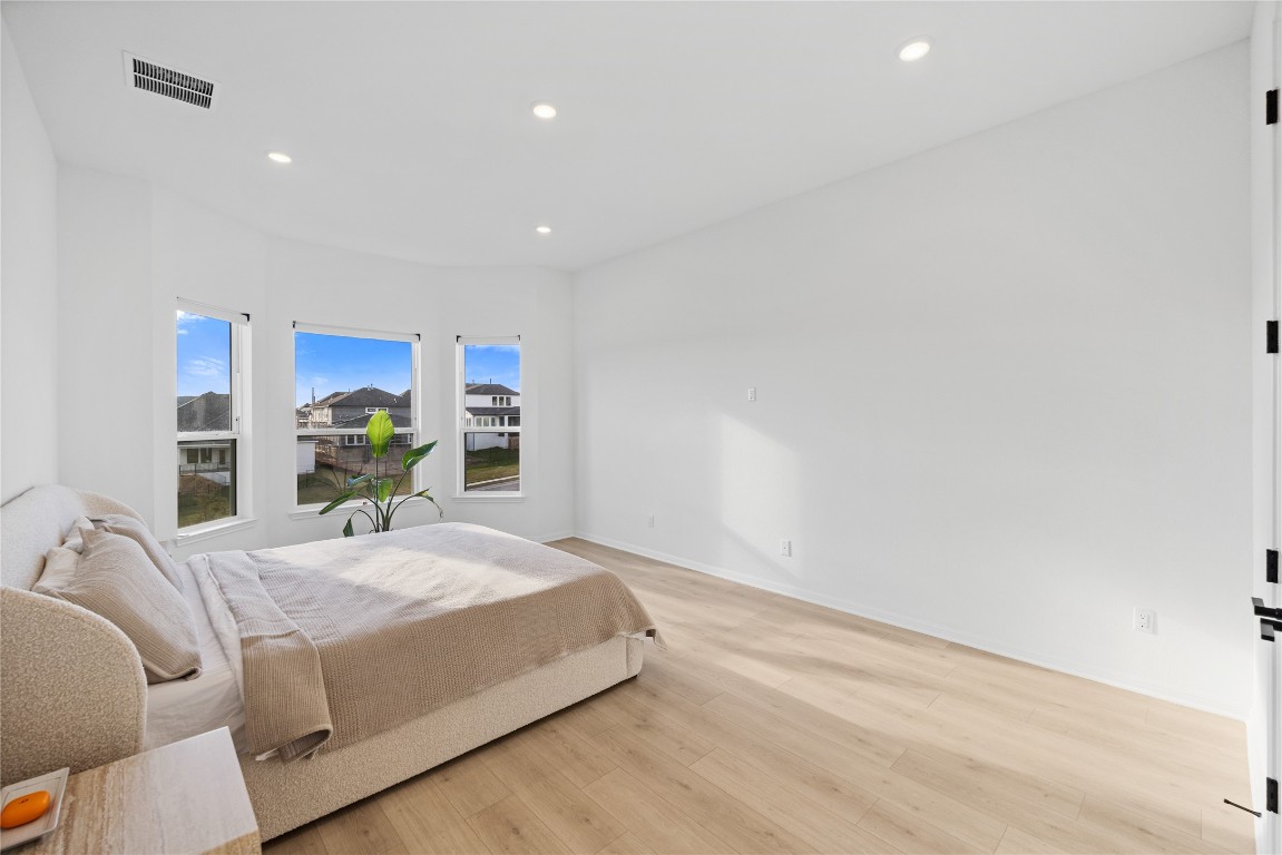 1953 Varese Path Leander, TX 78641 - Photo 10 of 36 a bedroom with a large bed and a potted plant
