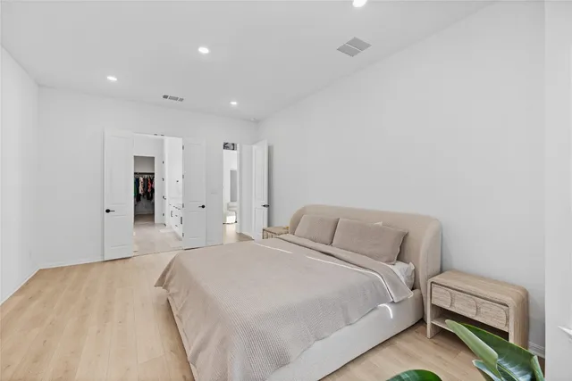 a bedroom with a large bed and a potted plant