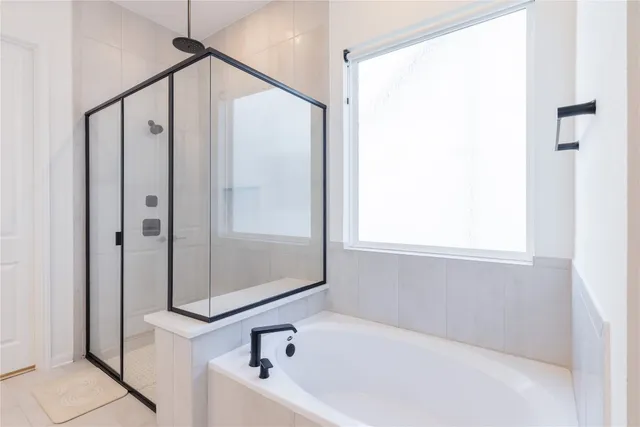 a spacious en suite bathroom with a double vanity sink a mirror and shower