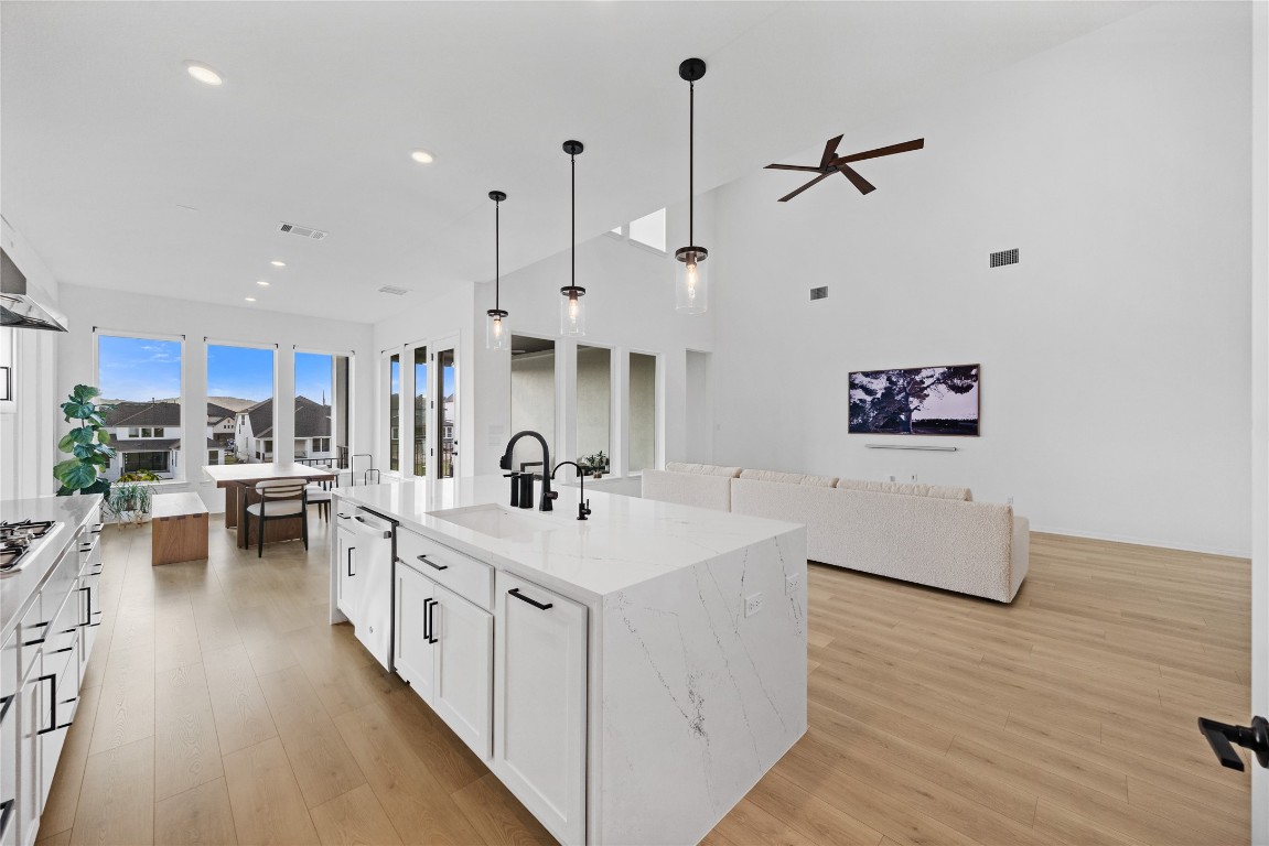1953 Varese Path Leander, TX 78641 - Photo 36 of 36 a kitchen with stainless steel appliances sink stove and white cabinets with wooden floor