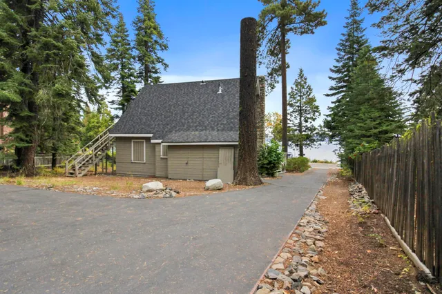 a view of swimming pool with lawn chairs and plants