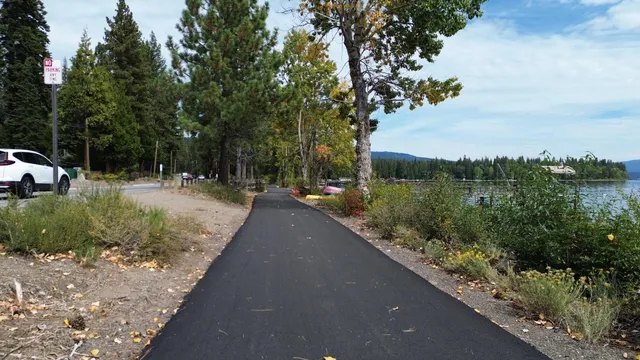 an aerial view of a house with yard and trees in the background