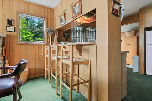 a view of a balcony with chairs and wooden fence