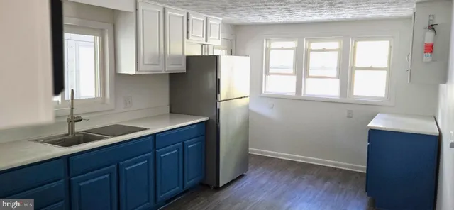 an empty room with windows and cabinet
