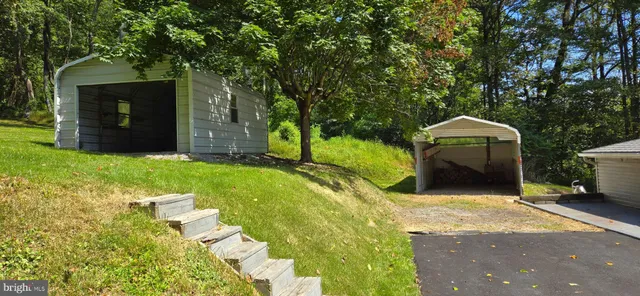 a view of a house with a yard and large tree