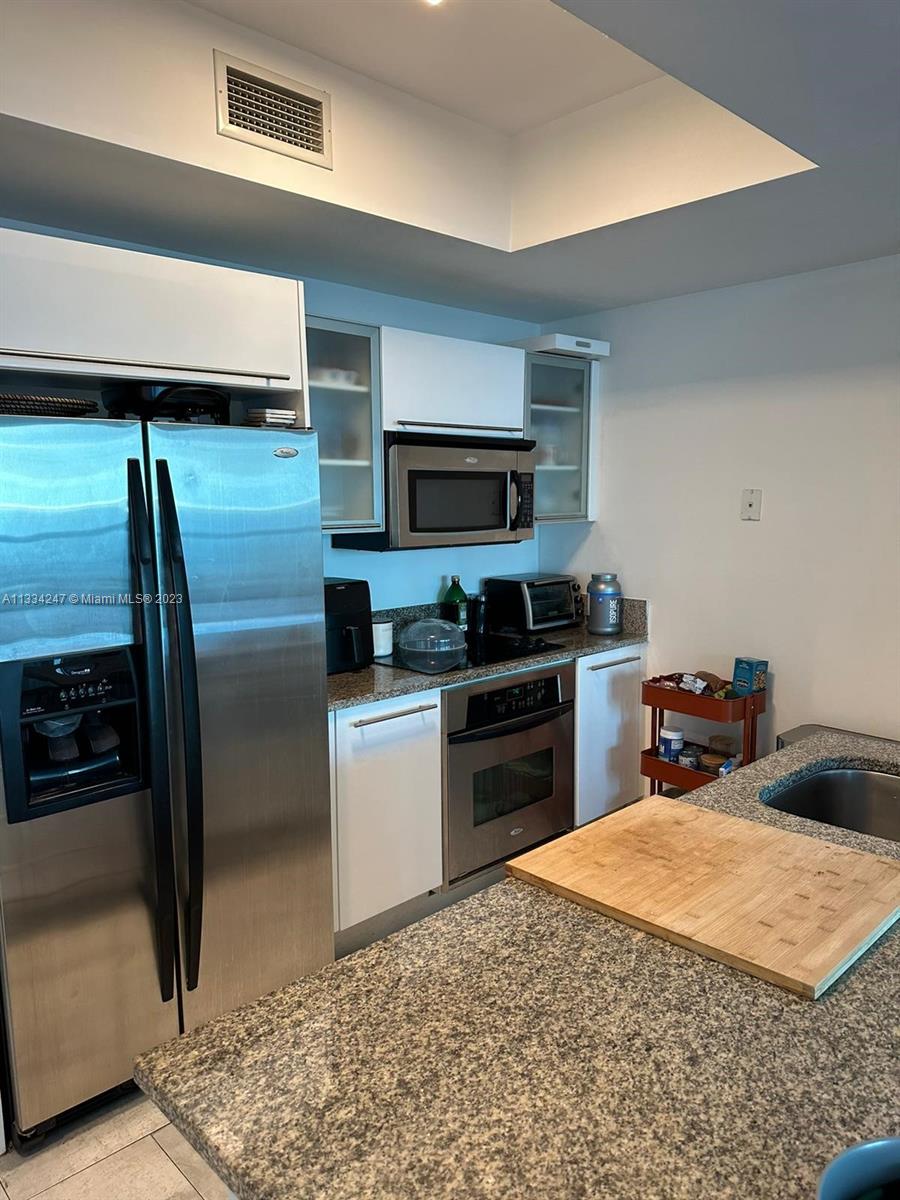888 Biscayne Boulevard, Unit 3611 Miami, FL 33132 - Photo 12 of 13 a kitchen with a refrigerator and a sink