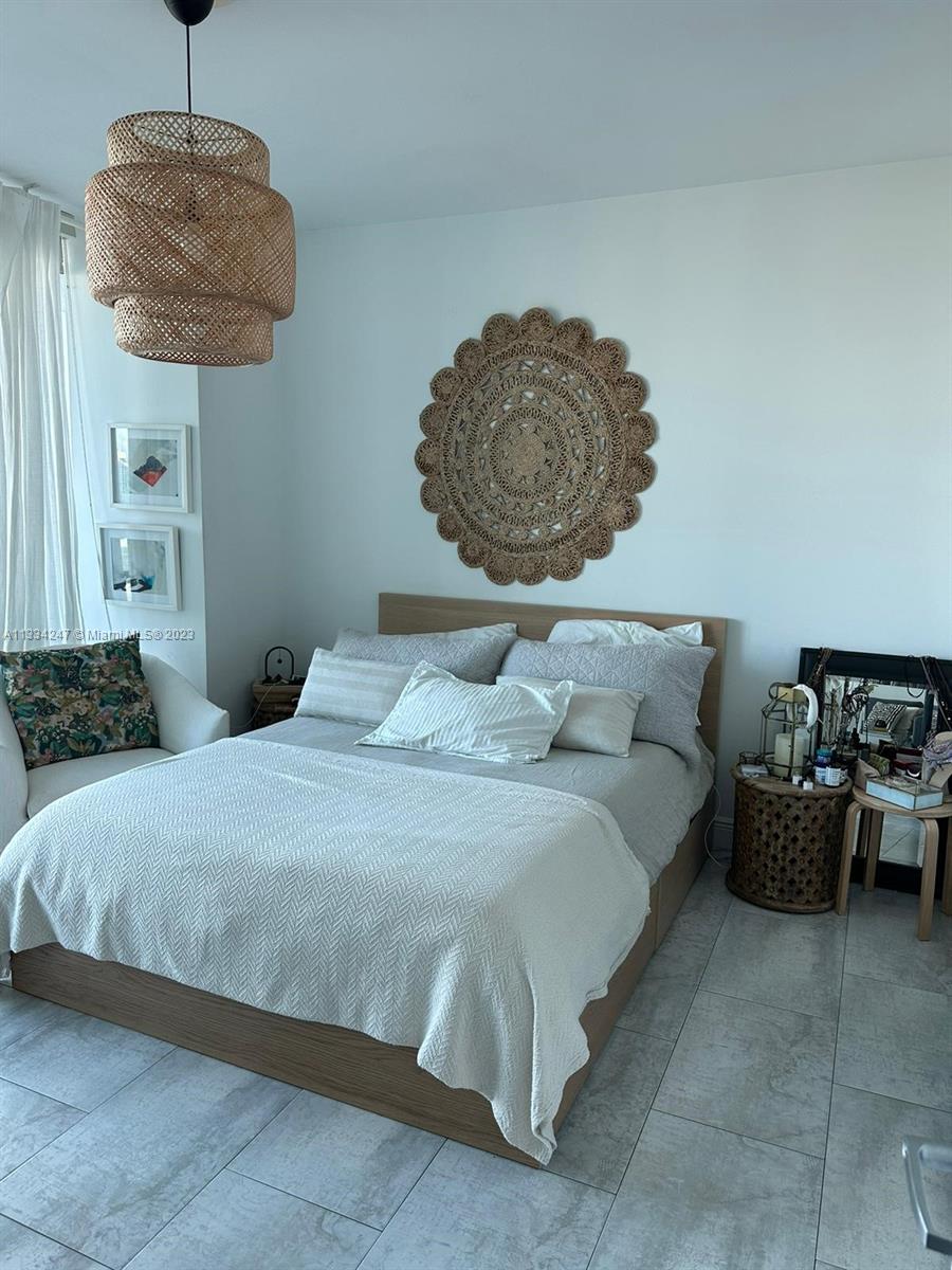 888 Biscayne Boulevard, Unit 3611 Miami, FL 33132 - Photo 3 of 13 a bedroom with a bed and a chandelier