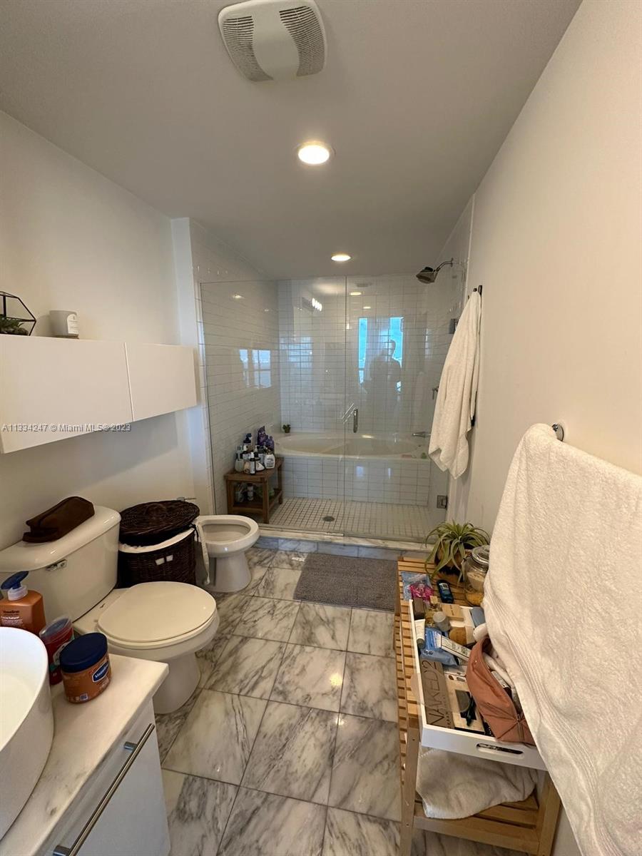 888 Biscayne Boulevard, Unit 3611 Miami, FL 33132 - Photo 8 of 13 a bathroom with a sink a toilet and a mirror