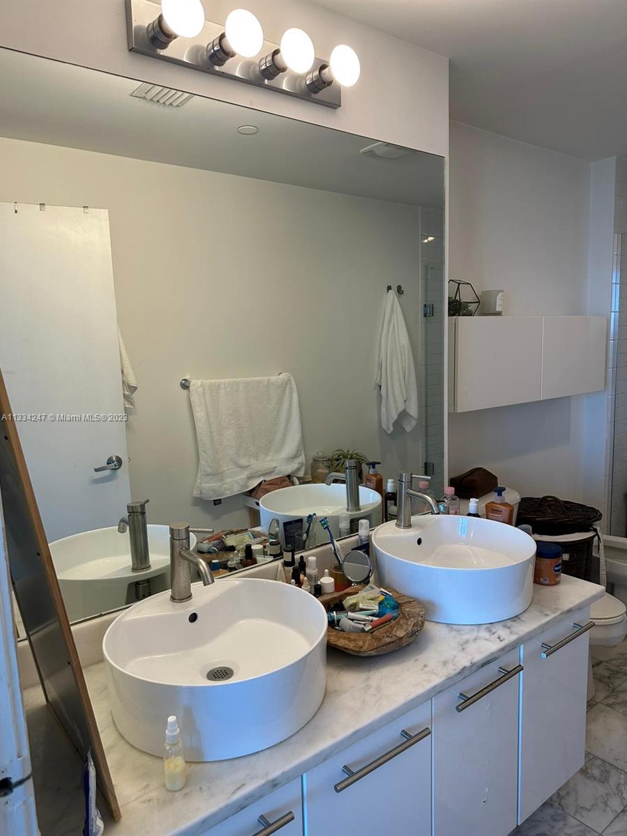 888 Biscayne Boulevard, Unit 3611 Miami, FL 33132 - Photo 9 of 13 a bathroom with a sink and a mirror