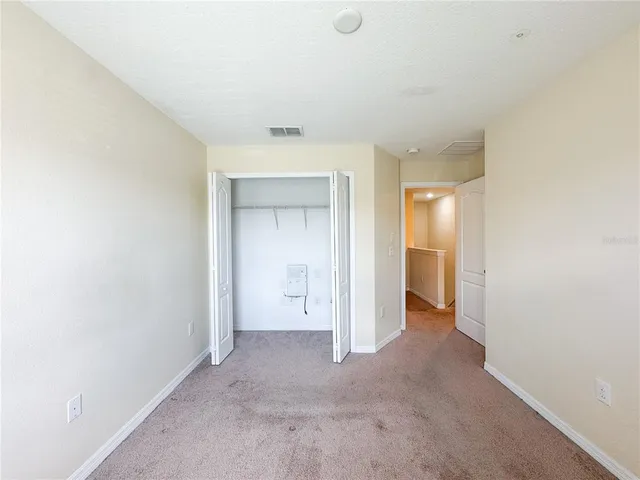 a view of an empty room with window and closet area